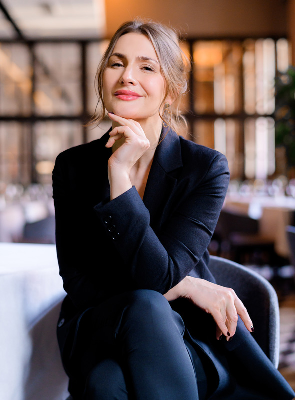 portrait-smiling-successful-businesswoman-looking-into-camera-sitting-restaurant-business-lady-with-stylish-hairstyle-wears-elegant-suit-business